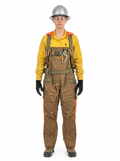 A person wearing a Willhammer Overall Suspender Harness, including a yellow shirt, brown quilted overalls, orange reflective trim, black gloves, and a silver hard hat, standing against a plain white background.